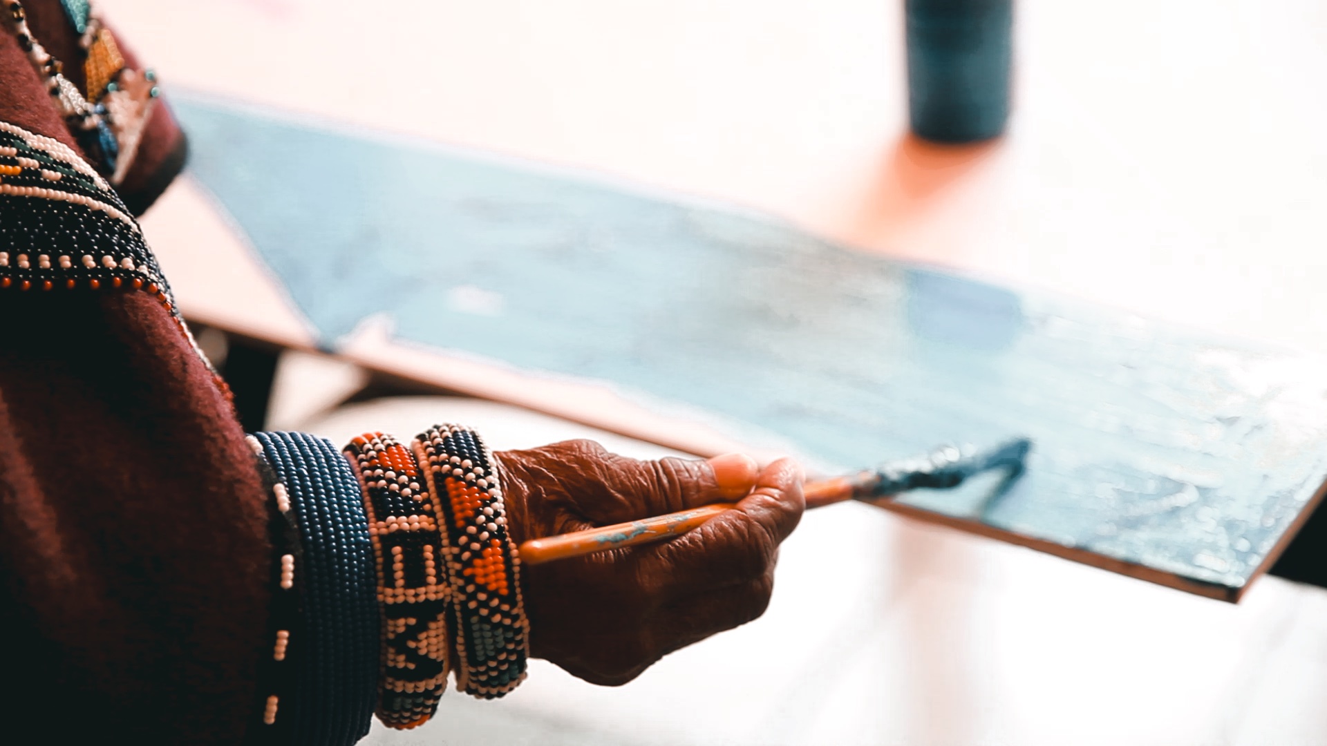 Dr Esther Mahlangu's hands painting, adorned with traditional Ndebele beaded bracelets