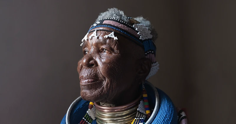 Dr Esther Mahlangu, chest-up studio portrait in traditional Ndebele beadwork and neck rings, by Clint Strydom