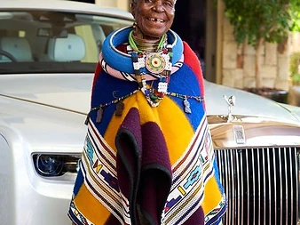 Dr Esther Mahlangu standing before the white Rolls-Royce Phantom
