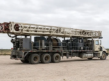 Mobile workover rig parked in a West Texas equipment yard.