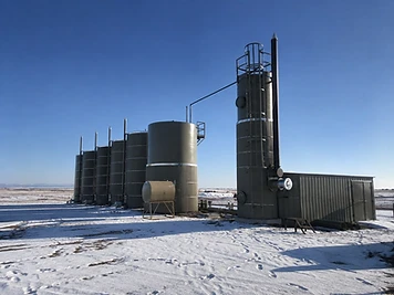 Production tanks and a vertical process vessel at a snow-covered DJ Basin site