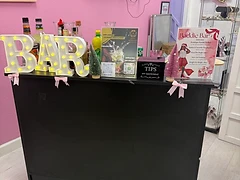 Baddie Bar themed pink boutique bar setup with light-up BAR marquee, holiday cocktail menu, and Elite Mixology branding