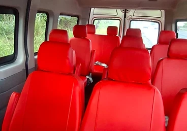 Van interior with red upholstered seats viewed toward the front