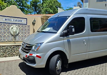 Silver passenger van parked at Hotel Parador entrance