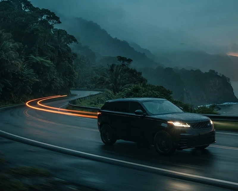 Luxury SUV on a misty Costa Rican mountain pass at blue hour