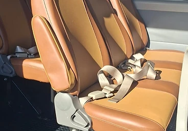 Van interior with tan dual-tone seats viewed toward the rear