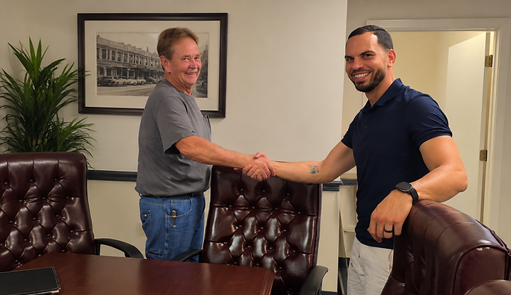 John Denman and Fernando Nando Núñez shaking hands at the Versatile Automotive purchase-offer signing in September 2026.