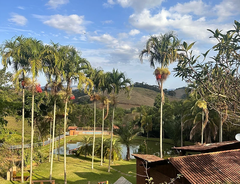 Vista do gramado, lago e colinas do Sítio Pedra Bonita em Miraí
