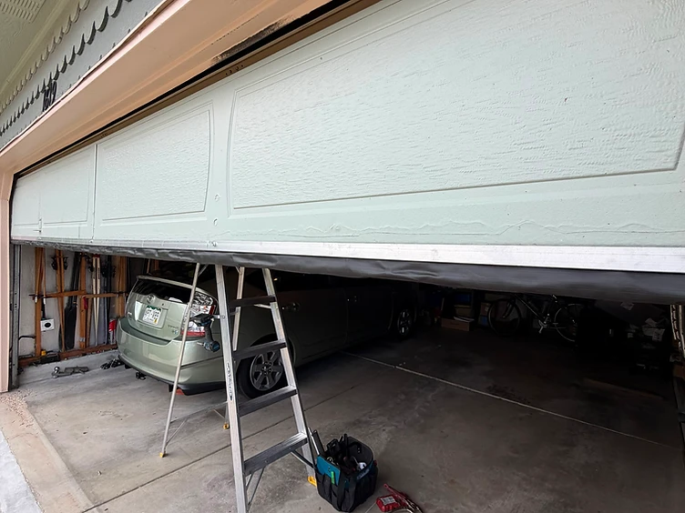 M Garage Door Repair technician servicing a garage door on-site in Northern Colorado