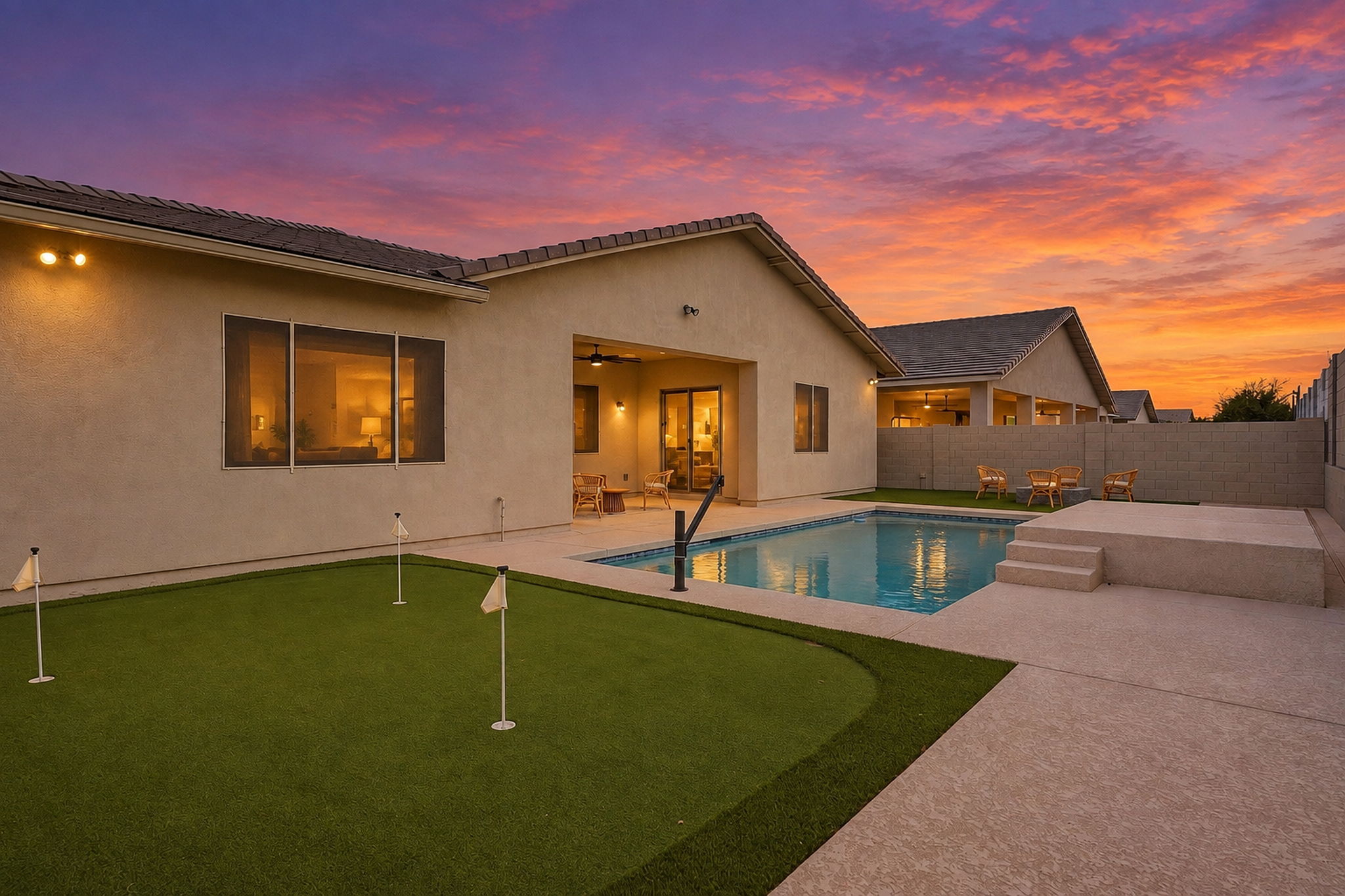 Backyard with pool and putting green at twilight
