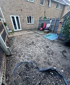 Garden before renovation — excavated ground, old slabs and tired fence