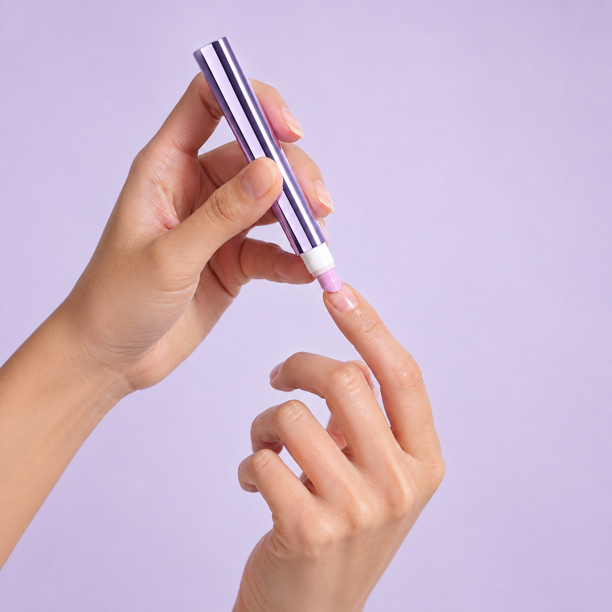 The VELLUVA pen gliding along a natural nail edge, a translucent oil sheen where the tip has been.