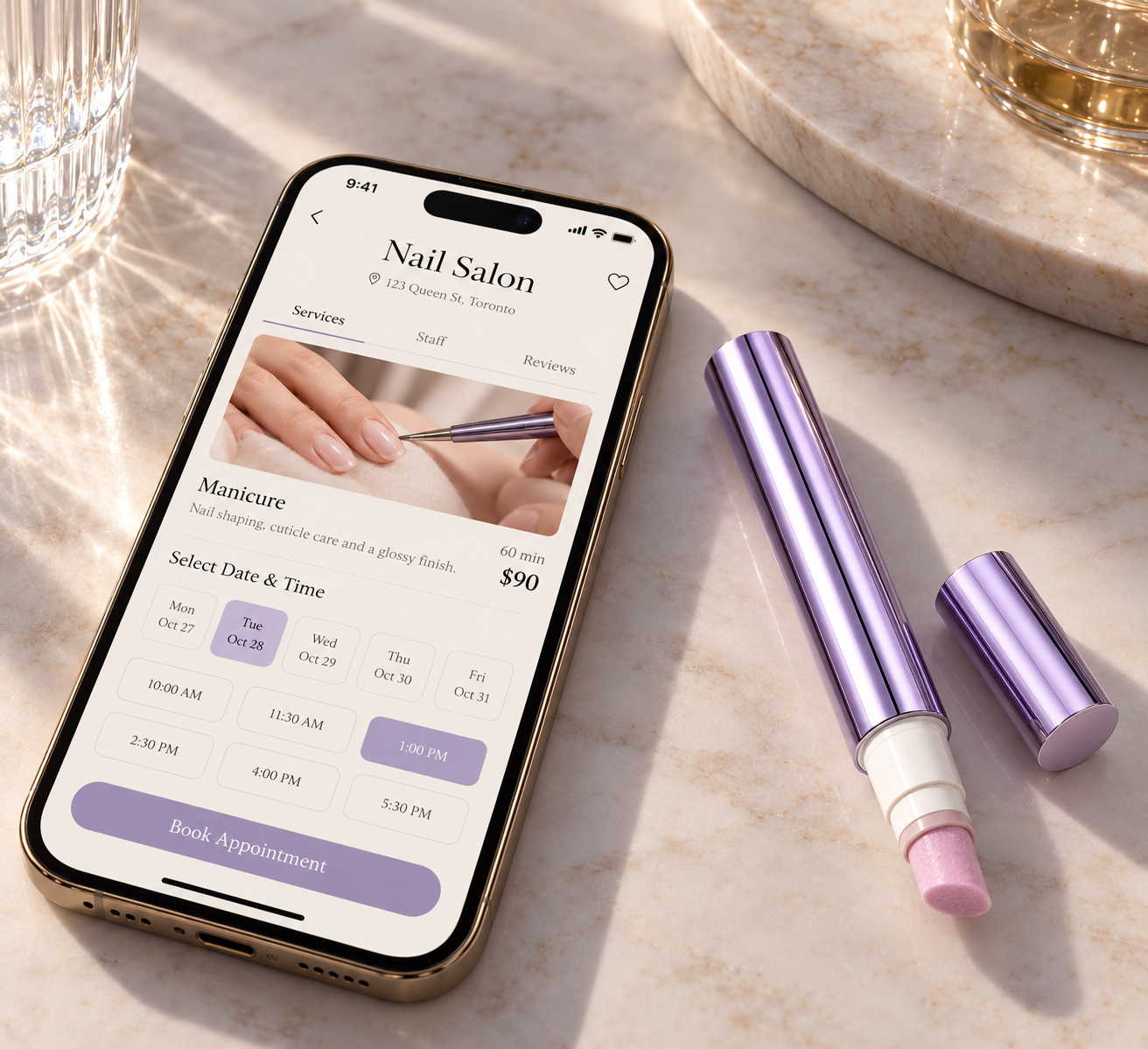 A phone showing a salon booking screen next to a VELLUVA pen on a table.