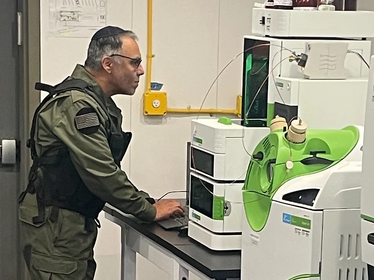 Tactical operator in plate carrier working at the lab bench