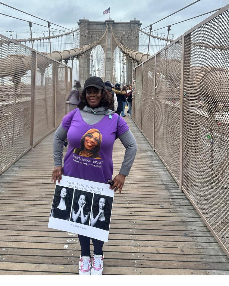 Mable walking across the Brooklyn Bridge in a purple shirt honoring Angie