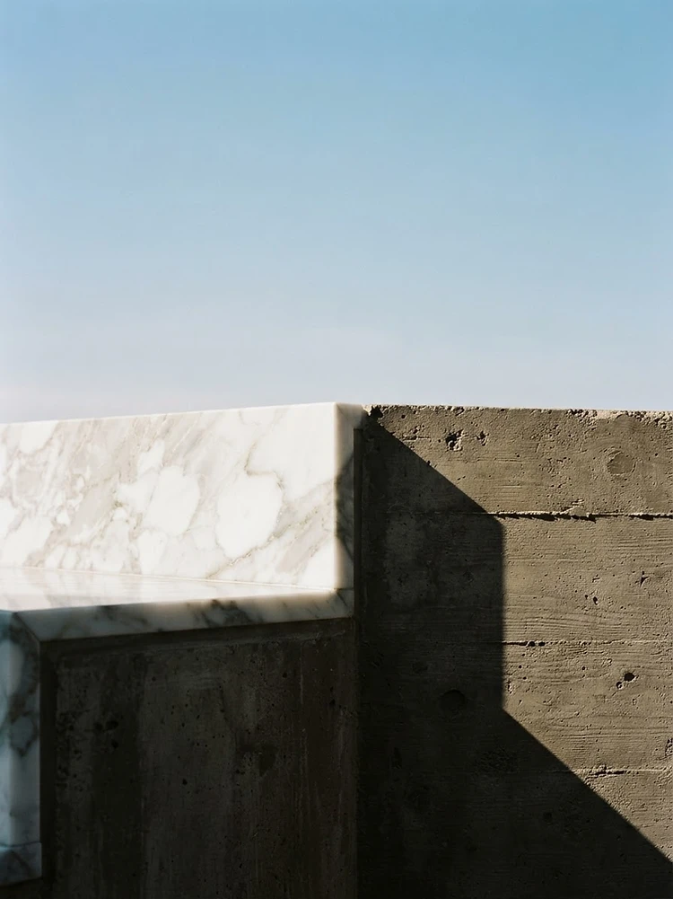 Brutalist concrete and marble architectural detail in chiaroscuro light