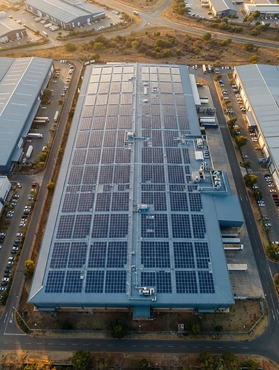 Aerial view of a commercial warehouse roof covered in solar panels