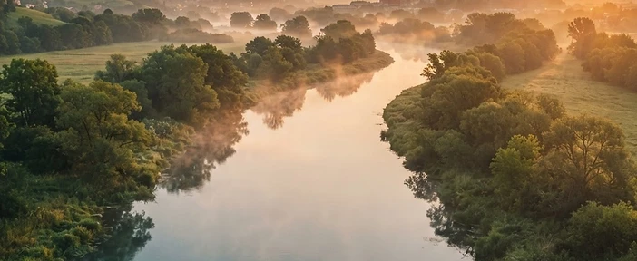The Vistula River in Poland at golden hour, mist over calm water
