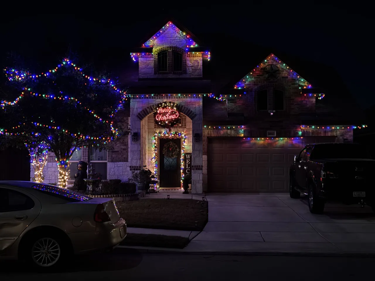 Multicolor Stone Home with Gable and Wreath, multicolor holiday lighting installation by Brilliance Lighting