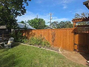 Finished stained wood fence with a decorative arched gate