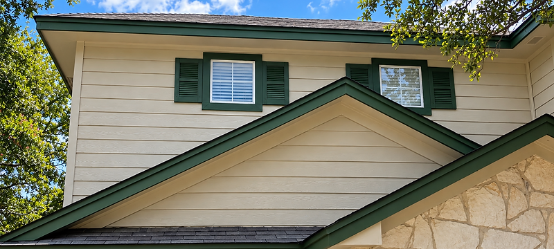 Finished Boerne home exterior with cream siding, green trim, and stone.