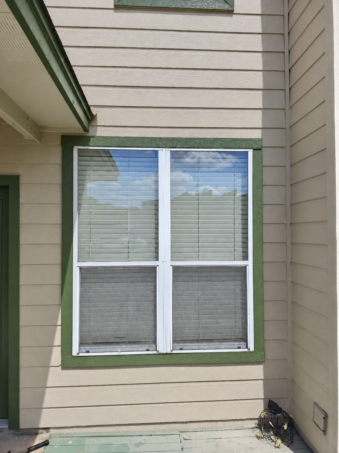 Finished courtyard window with green painted trim.