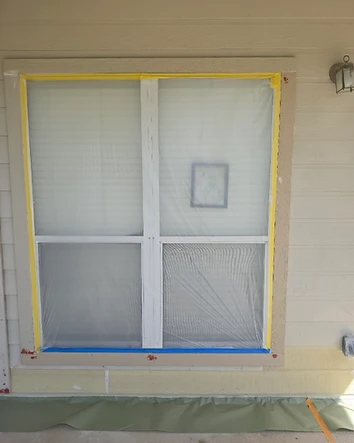 Repaired exterior siding and window protected with plastic before painting in San Antonio, Texas.