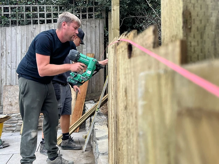Vertical timber fence being fixed with a string line for height alignment