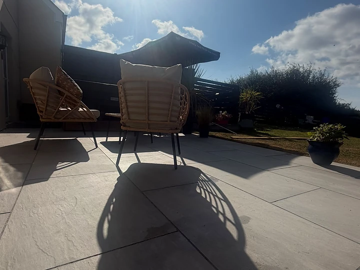 Completed stone patio with outdoor seating in bright daylight