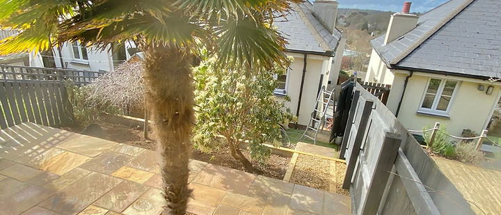 Newly laid natural stone patio with curved retaining wall in Cornwall