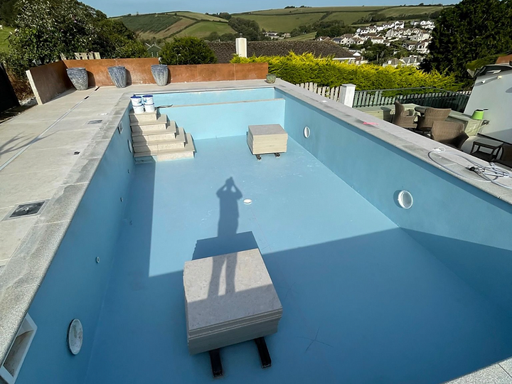 Swimming pool installation with stone paving and rural views