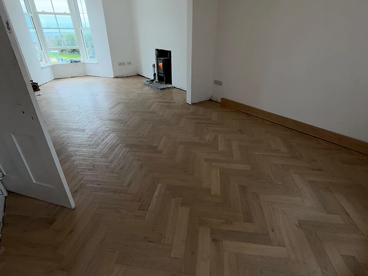 Completed light-oak herringbone flooring in a period living room