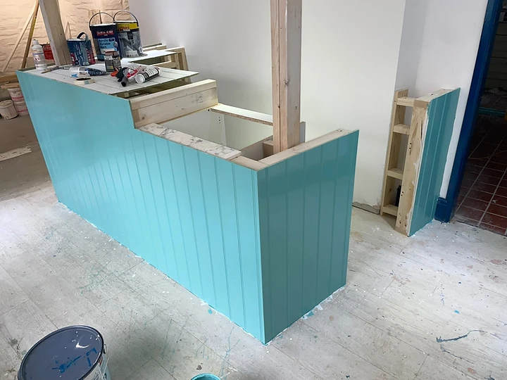 Painted tongue-and-groove counter and partition under construction