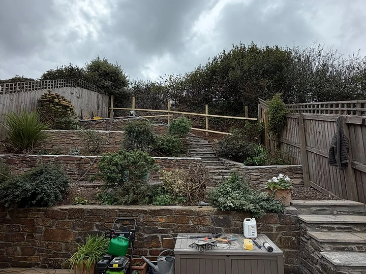 Tiered garden with stone retaining walls, decking and natural stone steps