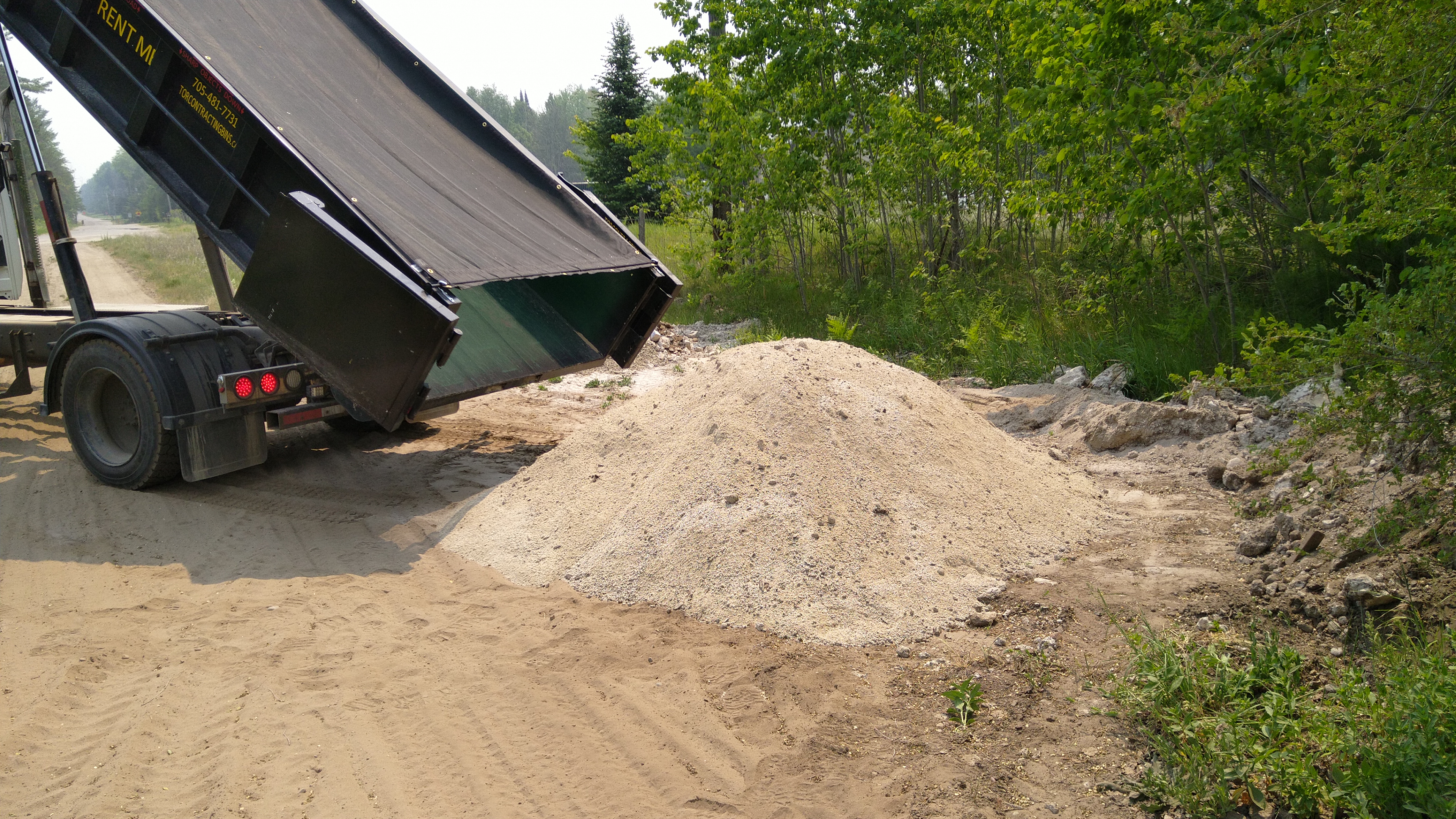 Tor Contracting dump truck unloading a pile of gravel on site