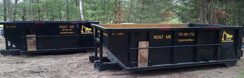 Two Tor Contracting roll-off bins with a forest backdrop