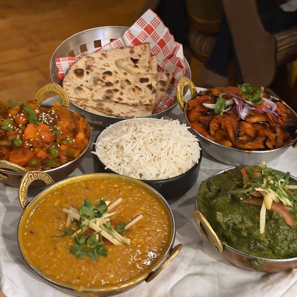 Copper serving dishes of curry, dal and rice
