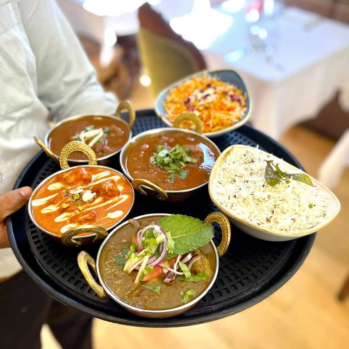 Assorted Indian curries on a copper tray