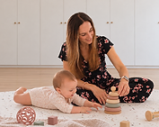 Kinesitherapeute speelt met een baby op een speelmat tijdens buikligging-tijd