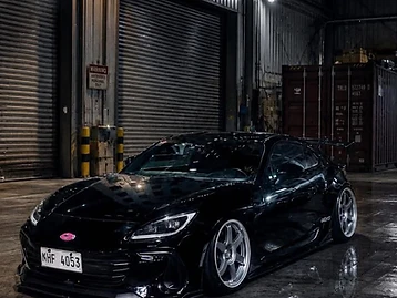 Lowered gloss-black Subaru BRZ sports coupe protected with Paint Protection Film inside an industrial TOKYOFILMS workshop.
