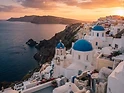 Santorini whitewashed buildings with blue domes at sunset