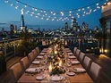 Rooftop celebration table with string lights at dusk