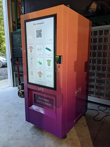 Lightly travel touchscreen vending machine with an orange-to-purple gradient body in a warehouse