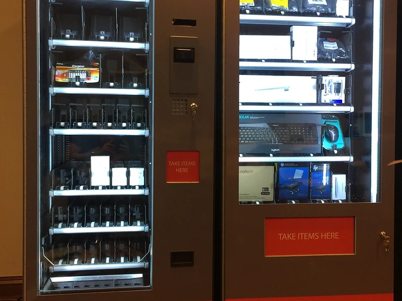 Dual gray Tesla branded vending machines side by side on a dark wood floor