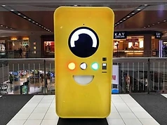 Bright yellow Snapbot vending machine in a shopping mall concourse