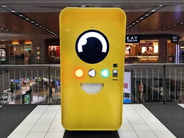 Bright yellow Snapbot vending machine in a shopping mall concourse