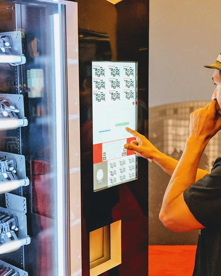 Man in a fedora interacting with a Toyota experiential touchscreen at a live event