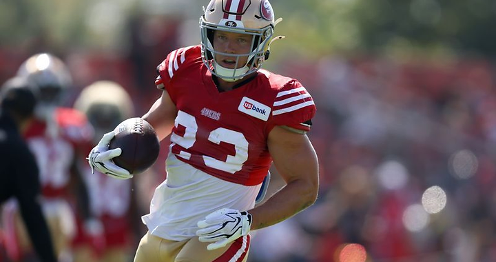 Christian McCaffrey in uniform carrying the football at speed