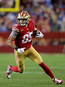 George Kittle carrying the football during a 49ers game