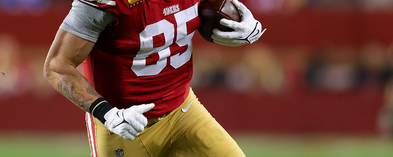 George Kittle carrying the football during a 49ers game